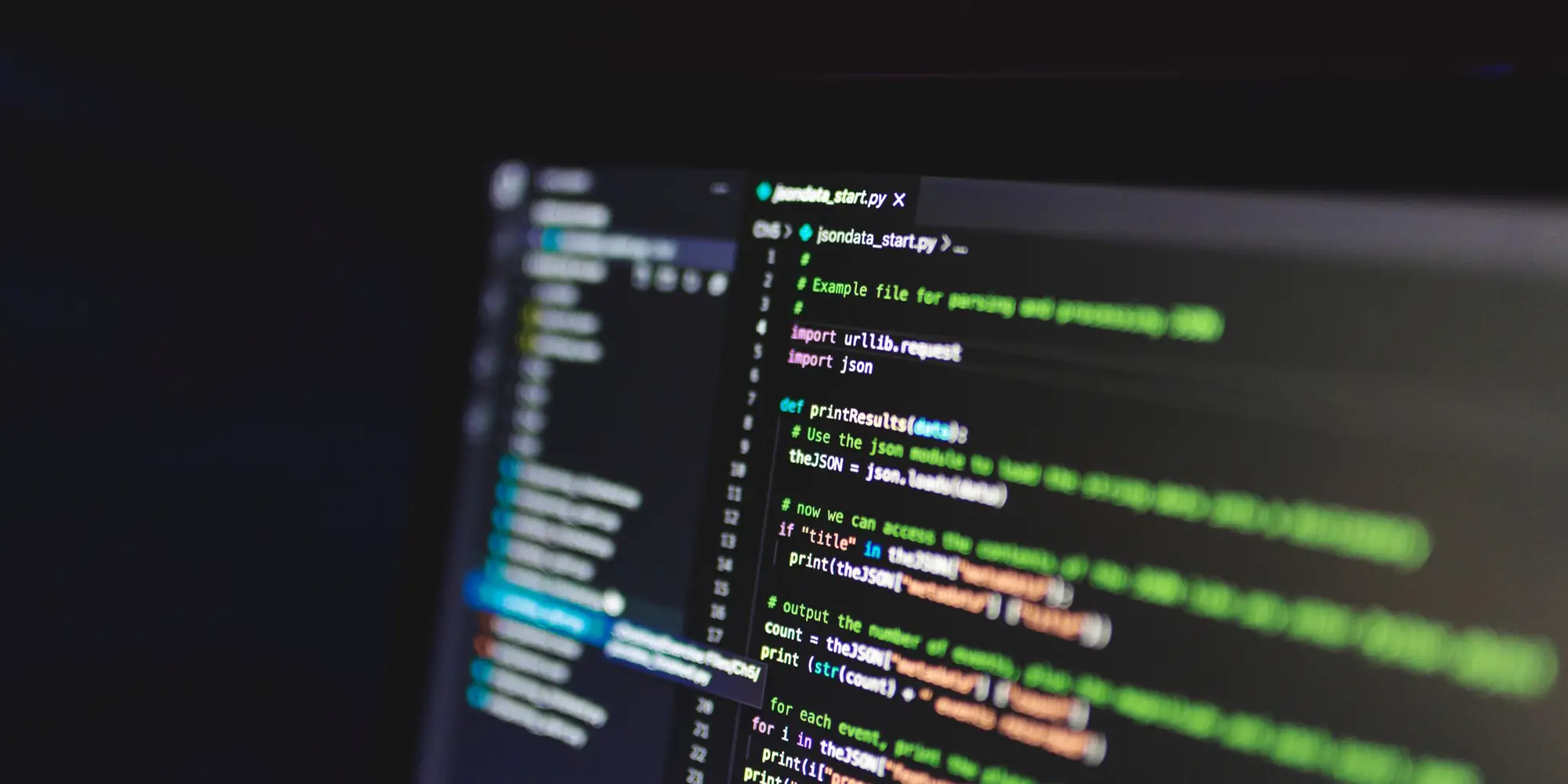Codice di un programma su un monitor, in una stanza buia